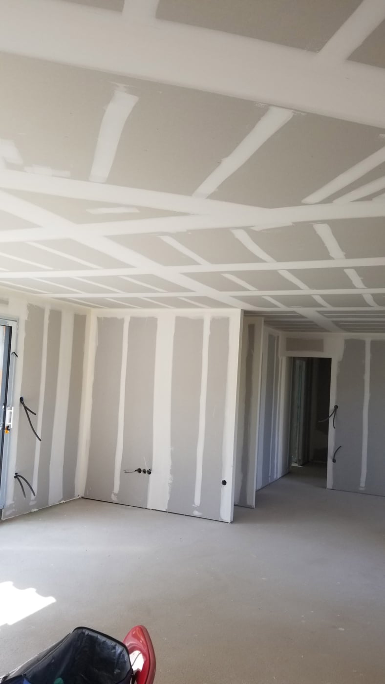 Travaux d'isolation et pose de plaques de plâtre par un plaquiste à Mont-de-Marsan dans une maison en rénovation, murs et plafonds préparés avec bandes et enduits